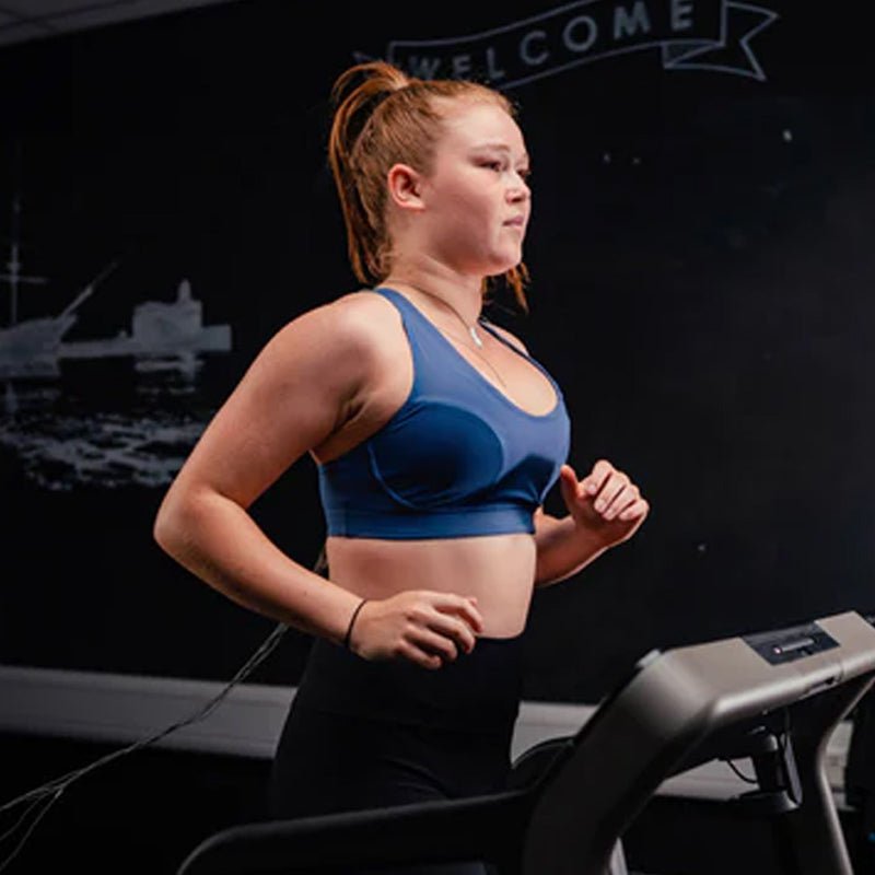 Image of a lady running wearing the blue energize running bra